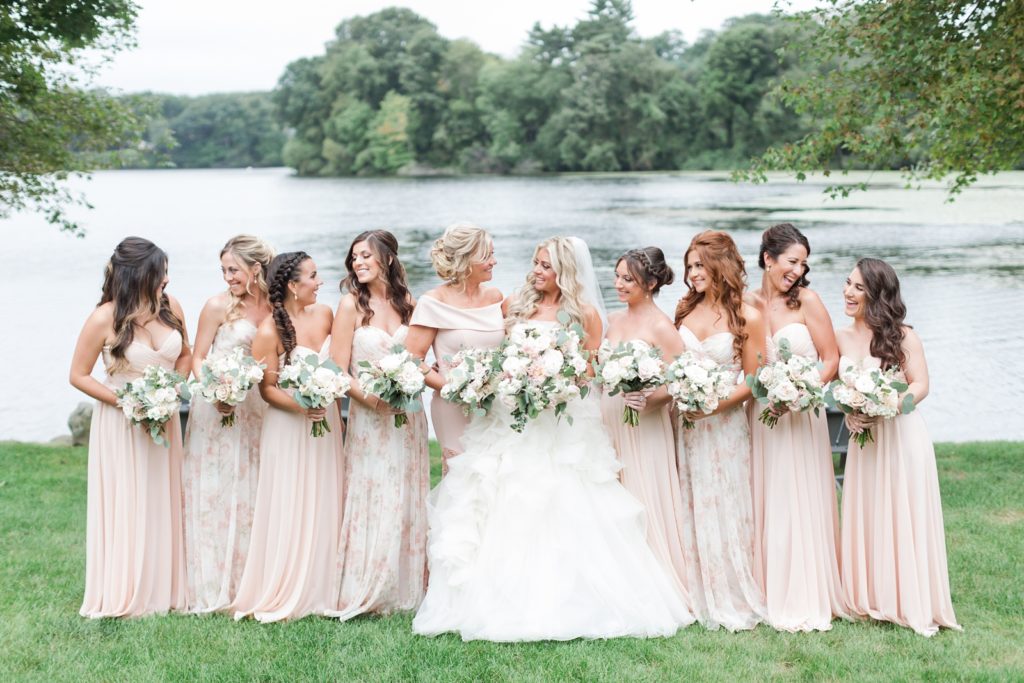 floral and blush bridesmaid dresses with beautiful wedding flowers by the lake at indian trail club wedding venue