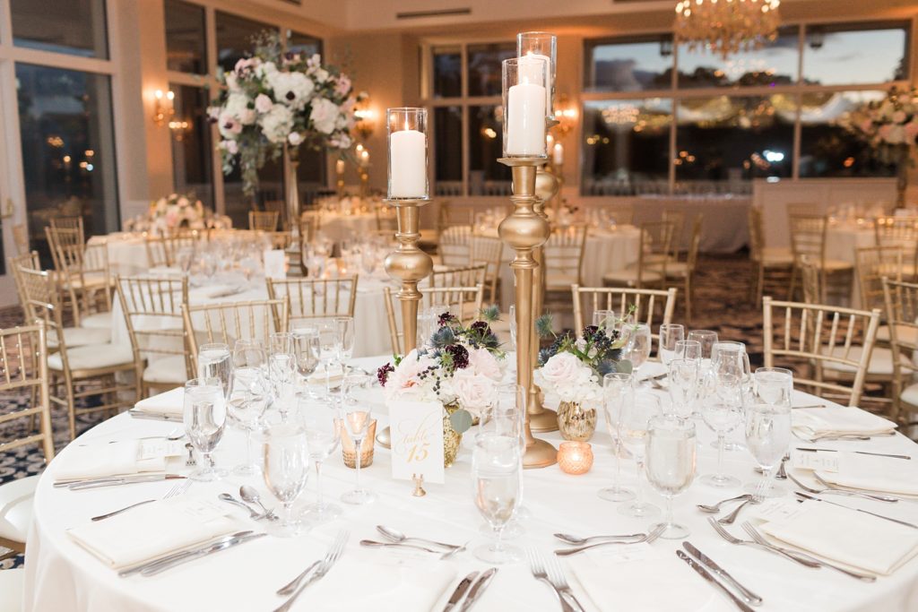 large gold votives and crystal glasses with white and blush roses for centerpieces at Trump National Golf Club Westchester