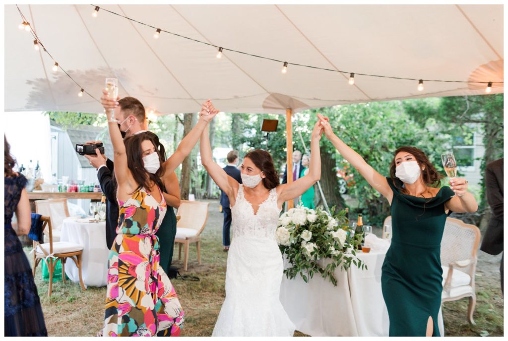 Bridal party celebrating in backyard tented wedding